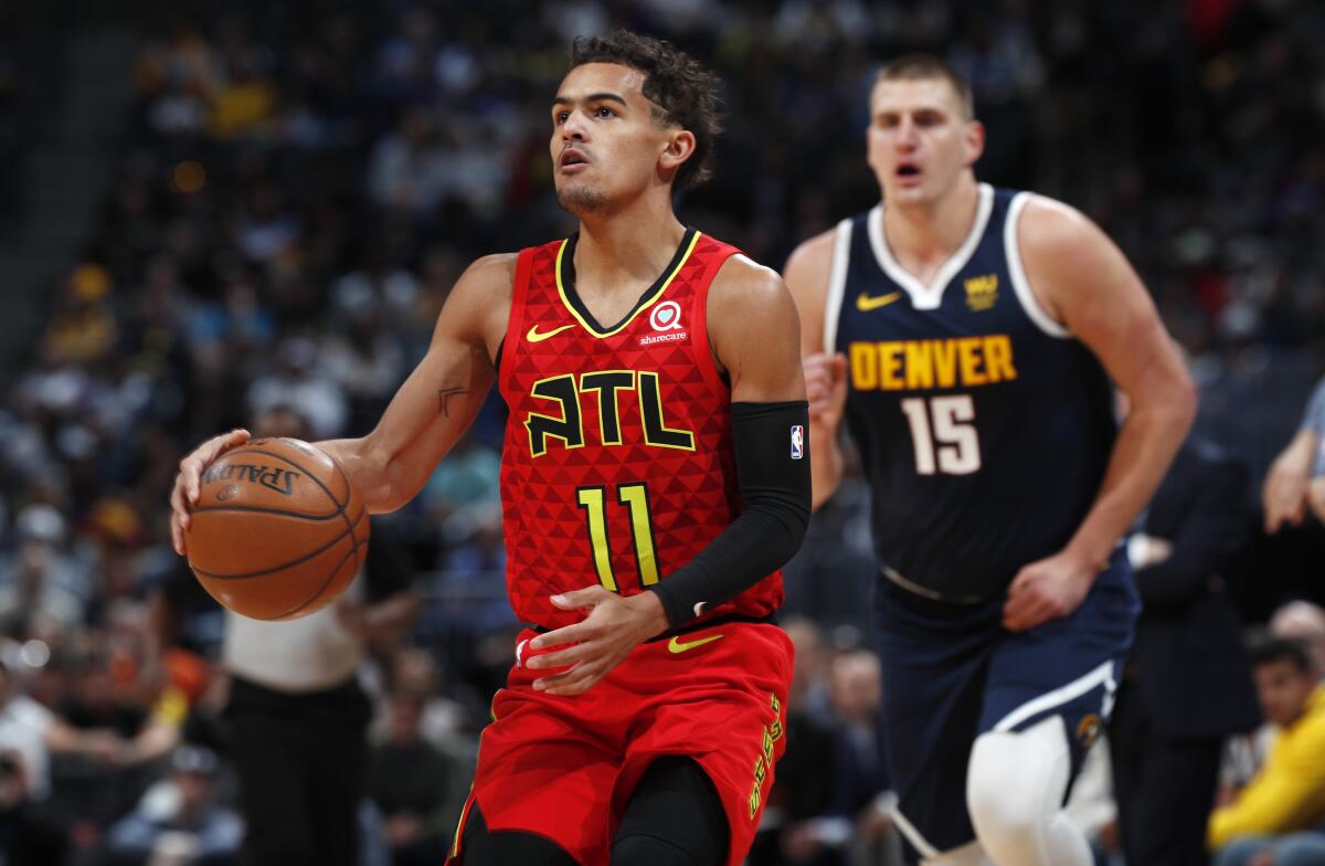 Trae Young about to shoot while Nikola Jokic is trailing behind.